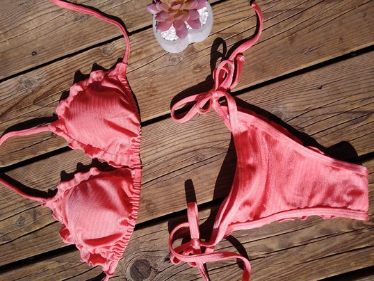 Flat lay of the orange Seena bikini - Jasikini swimwear.