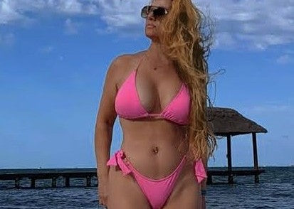 woman on the beach wearing a pink Jasikini bikini