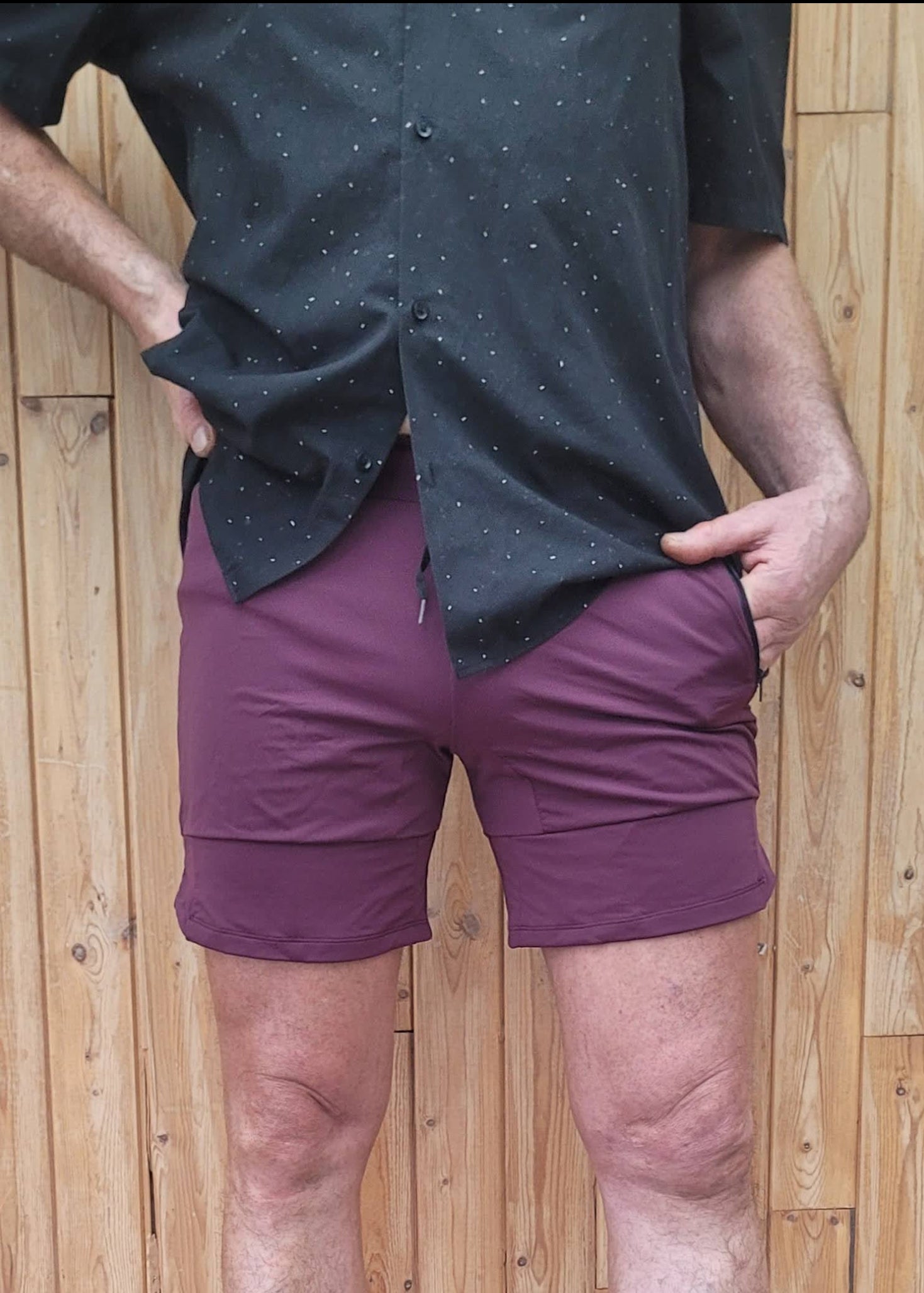 man wearing a black dress shirt and wine-red,medium length, swim shorts - Jasikini swimwear