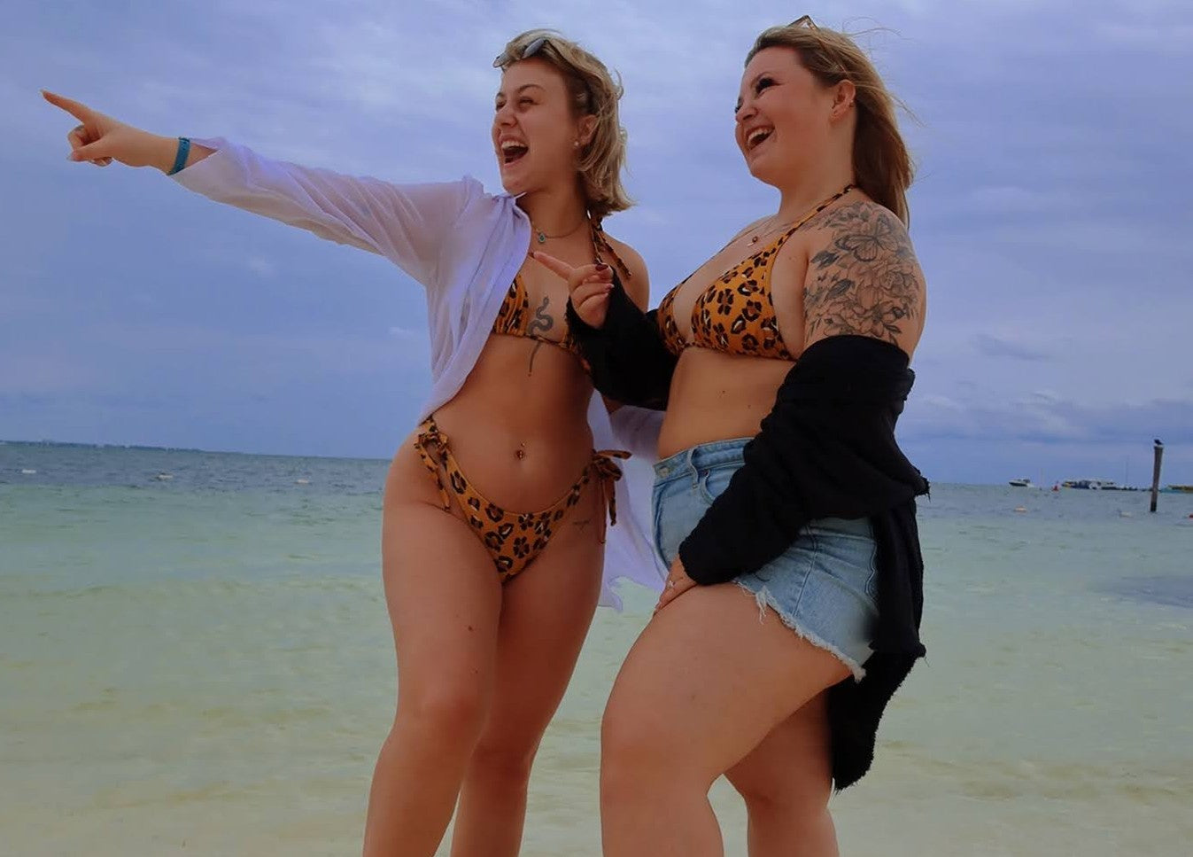 two girls being happy on the beach wearing jasikini swimwear