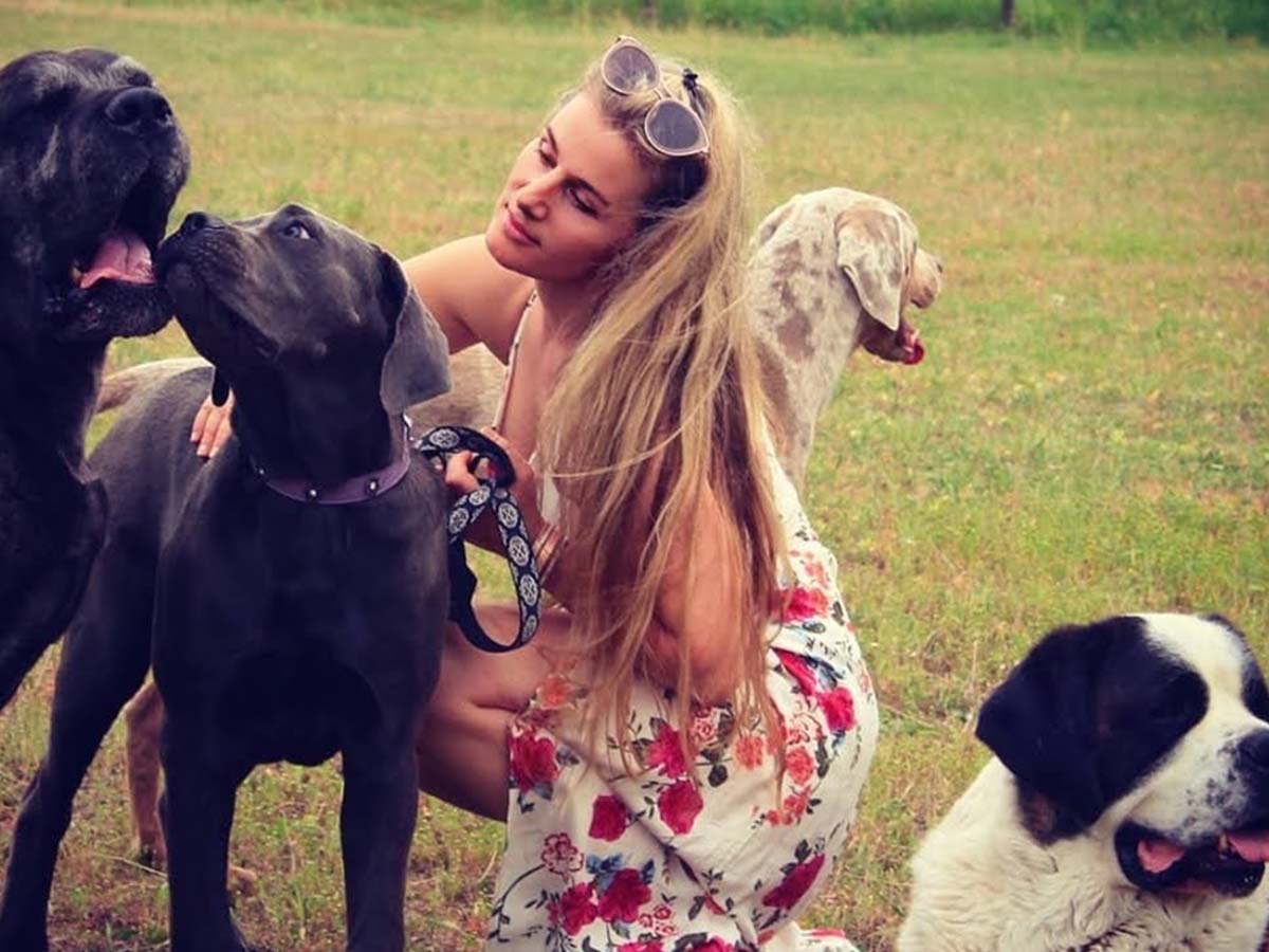 Jasmine from Jasikini swimwear with her dogs in a green pasture - Jasikini swimwear.