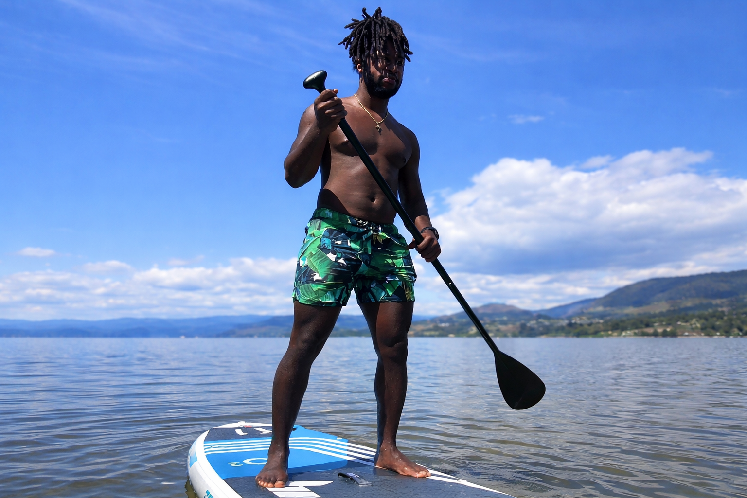 man on a paddleboard with jasikini swim trunks