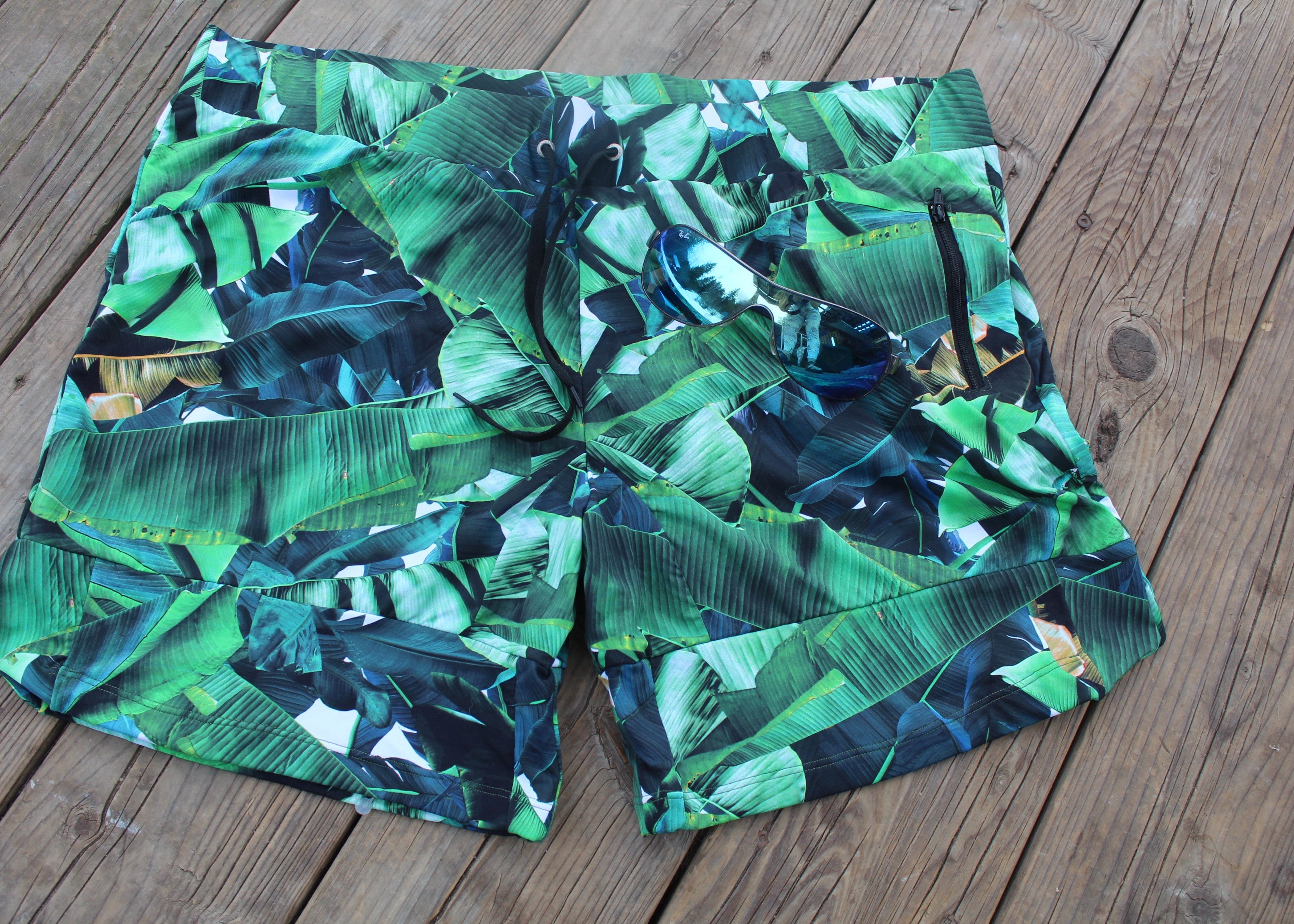 flat lay of palm leave patterened swim shorts - Jasikini swimwear